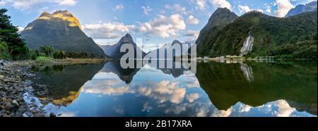 Nouvelle-Zélande, panorama panoramique des montagnes reflétant sur la surface brillante du Milford Sound Banque D'Images