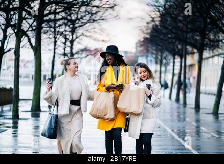 Les amies marchant dans la ville un jour de pluie Banque D'Images