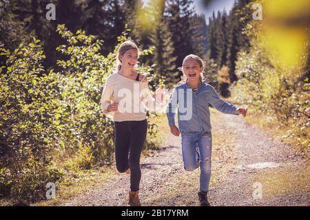 Les filles qui courir et s'amuser sur un sentier forestier dans la campagne Banque D'Images