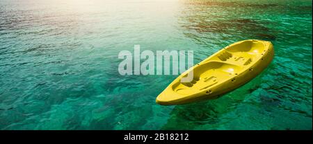 Canoë jaune flottant sur l'eau calme sous un incroyable coucher de soleil.vacances d'été et concept de voyage. Espace de copie Banque D'Images