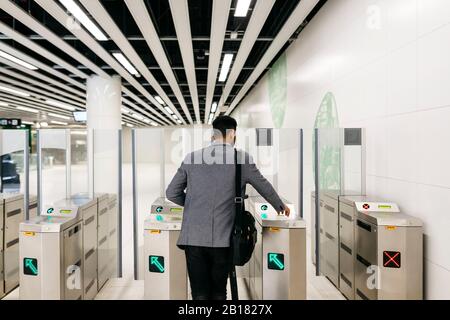 Vue arrière des jeunes hommes d'affaires entrant dans la station de métro Banque D'Images