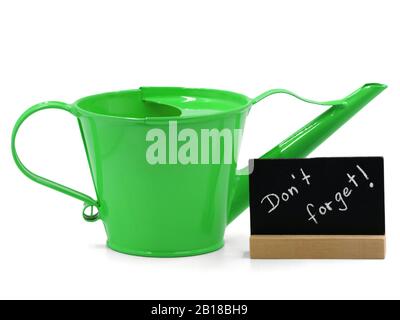arrosoir vert avec mini tableau noir isolé sur fond blanc, concept de ne pas oublier l'arrosage Banque D'Images