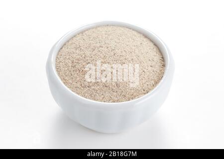 Poivre blanc moulu dans un bol blanc sur fond blanc. Utilisé comme épice dans les cuisines du monde entier. Banque D'Images