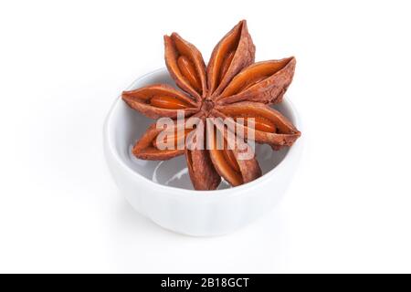 Étoile anis (Illicium verum) dans un bol blanc sur fond blanc. Aussi appelé anis étoile, ou anis étoile chinoise. Utilisé comme épice dans la cuisine Banque D'Images