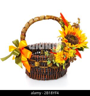 Panier en osier brun, décor rustique. Belles fleurs jaunes et grand tournesol jaune. Isolé sur blanc. Banque D'Images