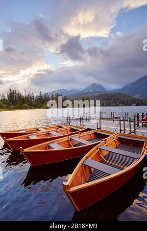 Berth avec des bateaux sur un lac de montagne dans les rayons du coucher du soleil. Banque D'Images