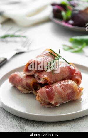 Délicieux cochons en couvertures, viande enveloppée dans du bacon, morsures de viande cuites maison. Photo de nourriture brillante. Banque D'Images