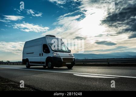 Une ambulance transporte un patient en conduisant sur la route au coucher du soleil. Véhicule de transport médical Banque D'Images