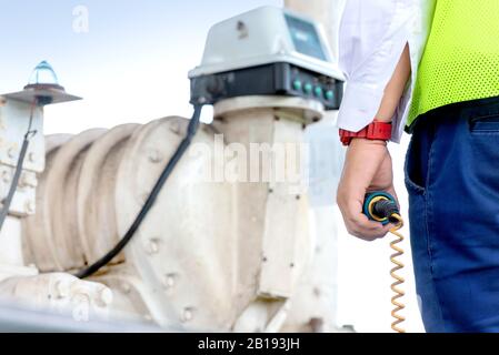 Agent de sécurité avec outils à sa main, en vérifiant un tableau de commande sur la base de carburant Banque D'Images