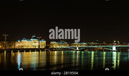 Pont de l'Université de Lyon le long du Rhône la nuit à Lyon France, bâtiment universitaire sur le fond Banque D'Images