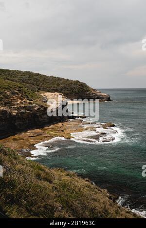 La côte accidentée du parc national Bouddi donnant sur la plage de Bullimah. Banque D'Images