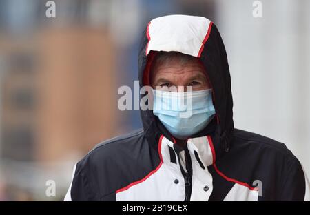 Comme de plus en plus de cas de Coronavirus / Covid-19 sont rapportés à travers le monde, y compris en Europe un homme au Royaume-Uni prend des précautions en portant un masque de visage Banque D'Images