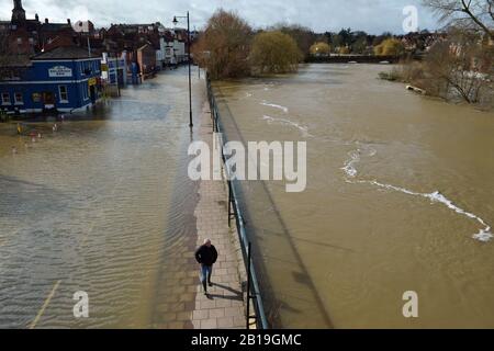 Un homme fait son chemin soigneusement entre la Smithfield Road inondée de Shrewsbury (à gauche) et la rivière Severn (à droite), comme d'autres avertissements d'inondation ont été émis en Angleterre et au Pays de Galles. Banque D'Images