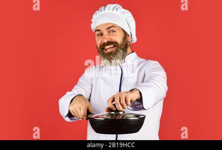 Petit-déjeuner fait maison. Cuisine comme pro. Repas savoureux et facile préparé à la maison. Récipient en céramique. Préparer la nourriture dans la cuisine. Concept de cuisine. Poêle à frire de haute qualité. Homme barbu cuisinier uniforme blanc. Banque D'Images