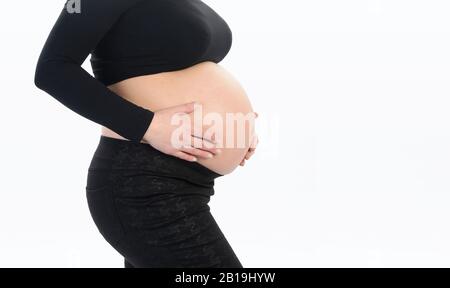 Femme enceinte avec les mains sur son ventre Banque D'Images