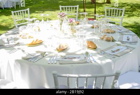 Décoration et ustensiles sur une table avec chaises préparées pour la célébration d'un événement en plein air. Banque D'Images