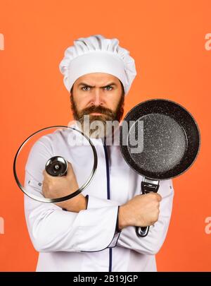 Cuisson régulière. Préparer la nourriture dans la cuisine. Concept de cuisine. Poêle à frire de haute qualité. Homme barbu cuisinier uniforme blanc. Cuisine comme pro. Repas savoureux et facile préparé à la maison. Petit-déjeuner fait maison. Banque D'Images