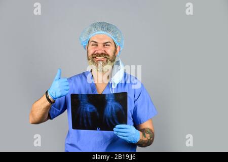 Urgence hospitalière. Le médecin compare les résultats. Rayonnement de rayons X. Le médecin possède des images d'os. Fracture et dommages osseux. Le médecin examine l'instantané radiographique du poignet. Le chirurgien estime les dommages. Banque D'Images