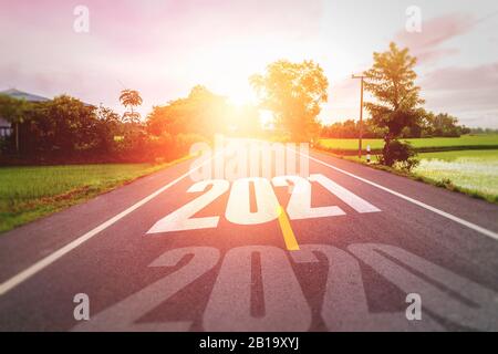 Concept nouvelle année Avec le mot 2020 à 2021 Écrit sur La route d'asphalte dans la route de campagne Décorer la lumière orange pour le concept de beauté pour la nouvelle année 2021 Banque D'Images