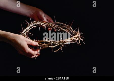 Mains Et Couronne De Thorns Sur Un Fond En Bois Noir Banque D'Images