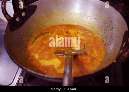 Curry indien de pommes de terre en cours dans un bateau rond appelé Karhai en hindi langue Banque D'Images