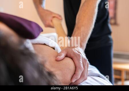 Femme adulte moyenne posée sur la table de massage dans le salon de beauté et prenant le massage. Massage thérapeutique du corps du spa. Un masseur professionnel faisant un massage Banque D'Images