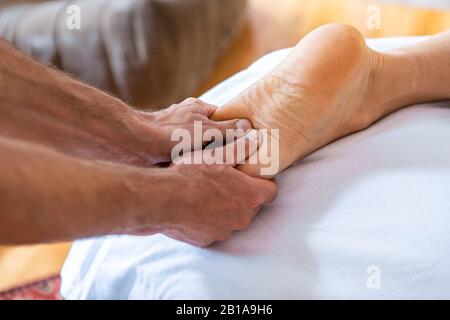 Jeune homme ayant des pieds massants dans le salon de spa. Massage sportif. Vue rapprochée des mains du masseur donnant un massage de traitement à son patient Banque D'Images