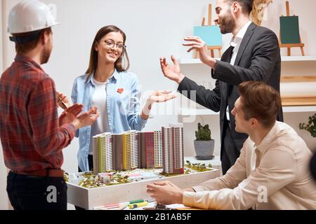femme architecte positif montrant le modèle de maison à sourire équipe dans son bureau. gros plan photo, bonheur, sentiment et émotion Banque D'Images
