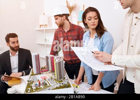 les jeunes employés de bureau qui terminent un projet, soumettant un modèle à leur patron.gros plan photo Banque D'Images