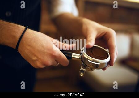 jeune homme apprenant à mousser du café, gros plan sur la photo. secret de la bonne préparation de l'espresso Banque D'Images