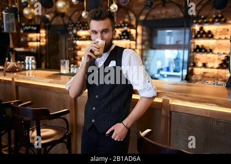 handsome shop owner having breakfast at workplace. close up photo. coffee break Banque D'Images