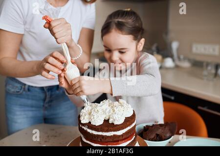 agréable fille souriante et sa mère préparant le gâteau pour la famille, la granny. gros plan photo. Banque D'Images