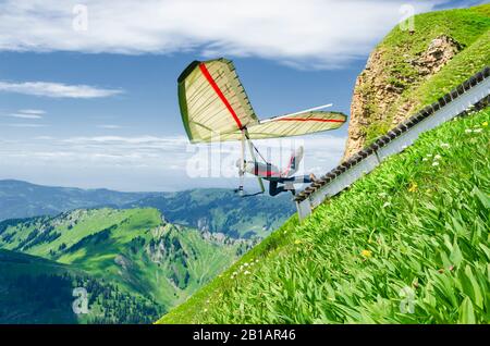 Les pilotes de deltaplane s'étend de la pente raide haute dans les montagnes. Diedamskopf, Autriche. Sport aérien extrême. Banque D'Images