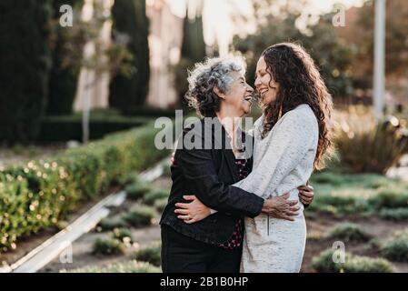 Grand-mère senior et fille adulte qui s'embrasse à l'extérieur Banque D'Images