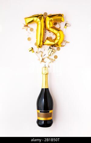 Heureux 75e anniversaire partie. Bouteille de champagne avec de l'or nombre ballon. Banque D'Images