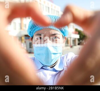 Une travailleuse médicale chinoise masquée fait un cœur avec ses mains lorsqu'elle retourne avec d'autres collègues à ses propres postes après 14 jours d'isolement et d'observation médicale après avoir travaillé dans le service d'isolement pour les patients infectés par le nouveau coronavirus et la pneumonie à l'hôpital No.4 Dans la ville de Huai'an, dans la province de Jiangsu en Chine orientale, le 22 février 2020. (Photo de Zhao Qirui / Costfoto/Sipa USA) Banque D'Images