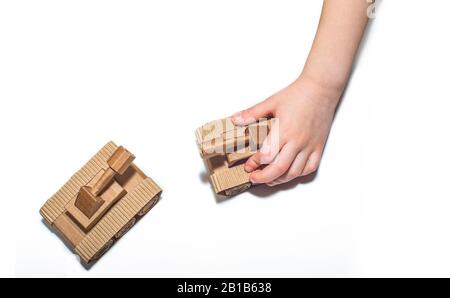 les mains des enfants jouent avec des tanks. deux tanks de jouets fabriqués par des enfants à partir de carton ondulé. des tanks de carton de jouet isolés sur un fond blanc. Banque D'Images