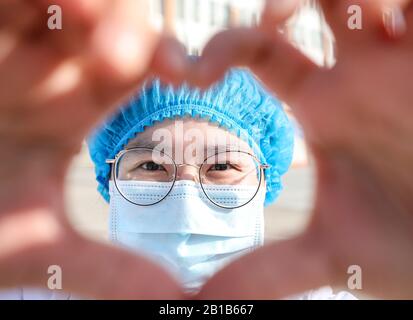 Une travailleuse médicale chinoise masquée fait un cœur avec ses mains lorsqu'elle retourne avec d'autres collègues à ses propres postes après 14 jours d'isolement et d'observation médicale après avoir travaillé dans le service d'isolement pour les patients infectés par le nouveau coronavirus et la pneumonie à l'hôpital No.4 Dans la ville de Huai'an, dans la province de Jiangsu en Chine orientale, le 22 février 2020. (Photo de Zhao Qirui / Costfoto/Sipa USA) Banque D'Images