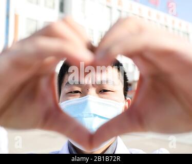Un médecin chinois masqué fait un cœur avec ses mains lorsqu'il revient avec d'autres collègues à ses propres postes après 14 jours d'isolement et d'observation médicale après avoir travaillé dans le service d'isolement pour les patients infectés par le nouveau coronavirus et la pneumonie à l'hôpital du peuple No.4 Dans la ville de Huai'an, dans la province de Jiangsu en Chine orientale, le 22 février 2020. (Photo de Zhao Qirui / Costfoto/Sipa USA) Banque D'Images