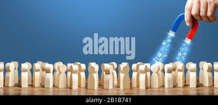 La main avec un aimant collecte les données personnelles des personnes. Confidentialité, protection de la vie privée. Fuite de données financières, perte de mot de passe. Phishing. Tr Banque D'Images