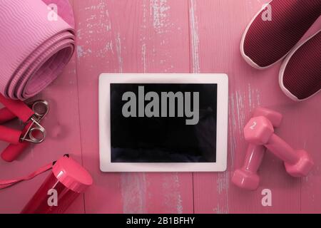 vue de dessus de la tablette numérique et des outils d'exercice sur fond rose Banque D'Images