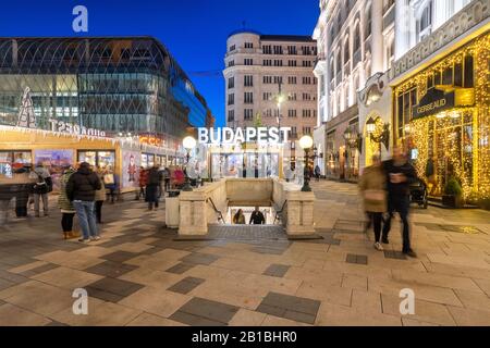 Budapest, Hongrie - 30 novembre 2019: Station de métro sur la place Vorosmarty avec marché des expositions de Noël en soirée. Banque D'Images