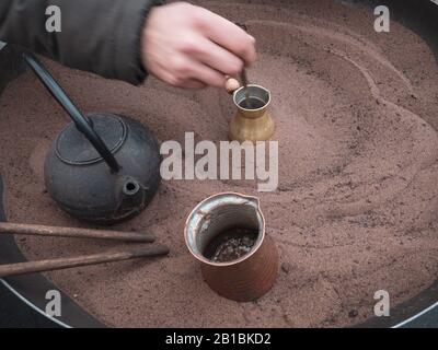 Café turc préparé avec de la préparation de sable chaud dans la rue pendant le festival de la nourriture. Aussi recette de café d'Egypte. Support traditionnel authentique Banque D'Images