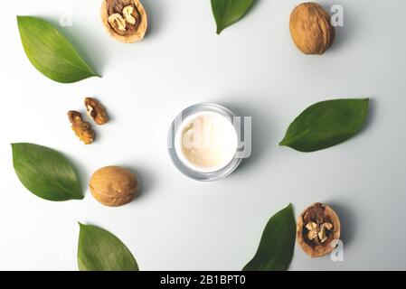Crème jaune à base d'ingrédients naturels sur fond bleu pastel avec feuilles vertes et noix. Le concept de création d'essences à partir de l'entrée naturelle Banque D'Images