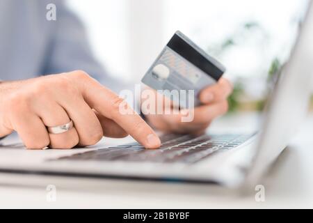 Mains tenant la carte de crédit et à l'aide d'un ordinateur portable. Concepts de paiement et d'achat en ligne. Banque D'Images