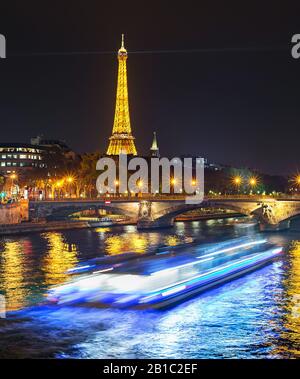 PARIS, FRANCE - 10 NOVEMBRE 2018 : Bateau de tourisme par Siene river et de la Tour Eiffel avec feux de la nuit à Paris. Banque D'Images