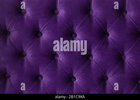 Tissu en velours ouatiné violet de couleur pourpre boutonné motif mural arrière-plan. Élégant canapé-lit de luxe vintage. Intérieur en toile de fond Banque D'Images