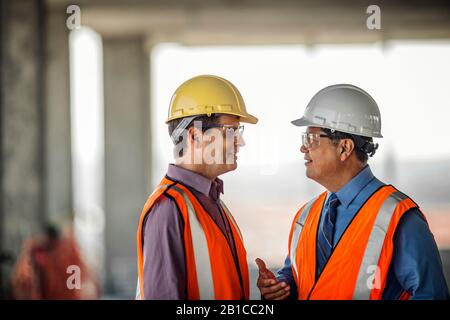 Deux directeurs de la construction en conversation sur chantier. Banque D'Images