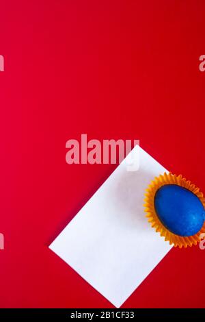 Vue sur la couche plate de l'oeuf de pâques coloré. Œufs de pâques décorés sur fond rouge. Carte blanche vide. Espace de copie. Joyeuses Pâques. Image verticale. Tragiti Banque D'Images