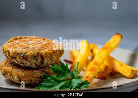 Patties de pois chiches végétaliens avec frites au four. Banque D'Images